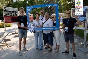 Osoby robią sobie zdjęcie w ramce festiwalu.