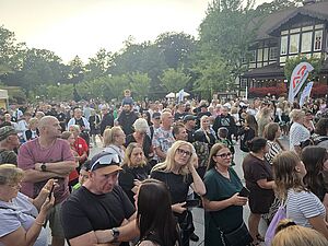 Licznie zgromadzona publiczność obserwująca plenerowe wydarzenie na świeżym powietrzu