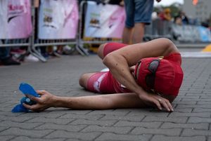 Zdjęcie przedstawia zmęczonego zawodnika na mecie biegu głównego.