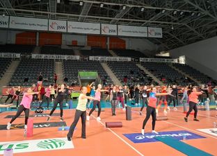 Tłum kobiet podczas rozgrzewki. Na ziem obok nich wałki i kalimaty
