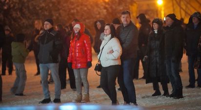 Grupa spokojnych osób stojąca na placu
