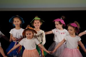 dzieci przebrane za kwiaty tańczą na scenie