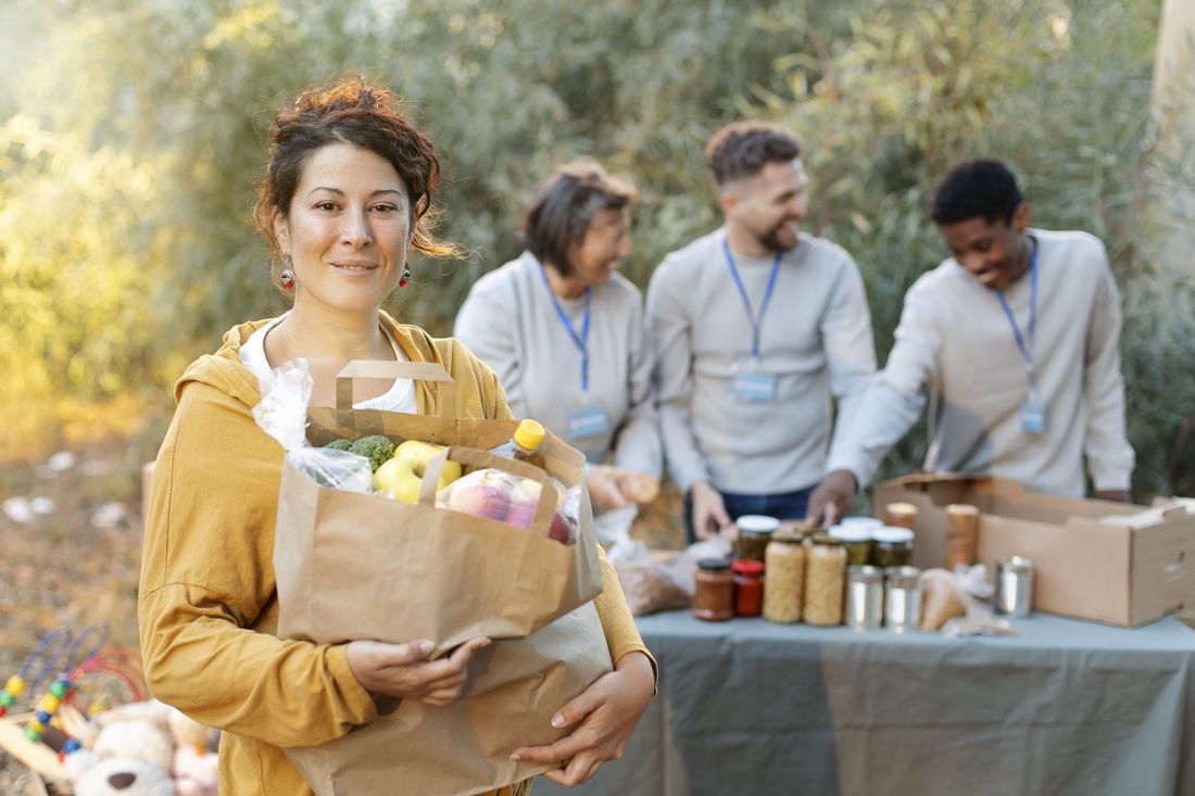 Grafika przedstawia kobietę z torbą i ludzi w tle.