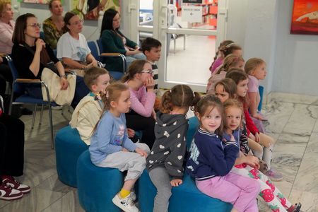 Ujęcie z boku dzieci siedzą i słuchają