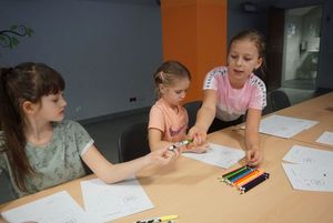Grupka dzieci rysuje 