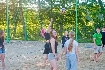 Młodzież gra w siatkówkę plażową na piaszczystym boisku