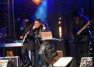 Wokalista One Night Band przystawia ucho, żeby lepiej słyszeć publiczność
