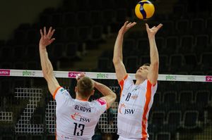 Kampa rozgrywa piłkę nad siatką.