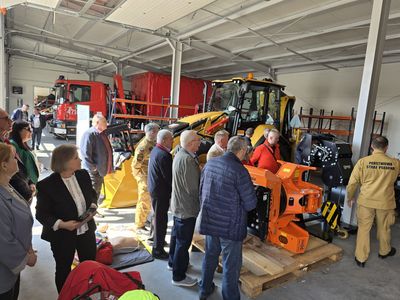 Większa perspektywa na zwiedzaną halę z wozem strażackim, spycharką
