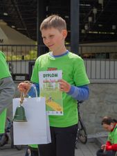 Chłopiec z dyplomem i dzwonkiem w ręku