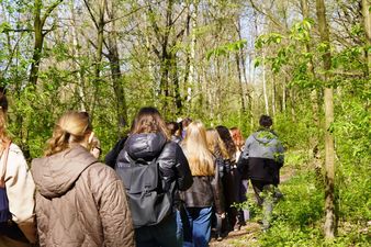 Studentki idące ścieżką między drzewami