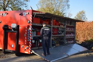Strażacy podczas ćwiczeń -zdjęcie przy wozie strażackim