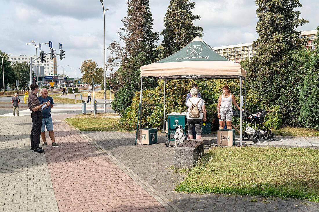 Punkt konsultacyjny na terenie otwartym przed galerią w zadaszonym namiocie z napisem Jastrzębie-Zdrój