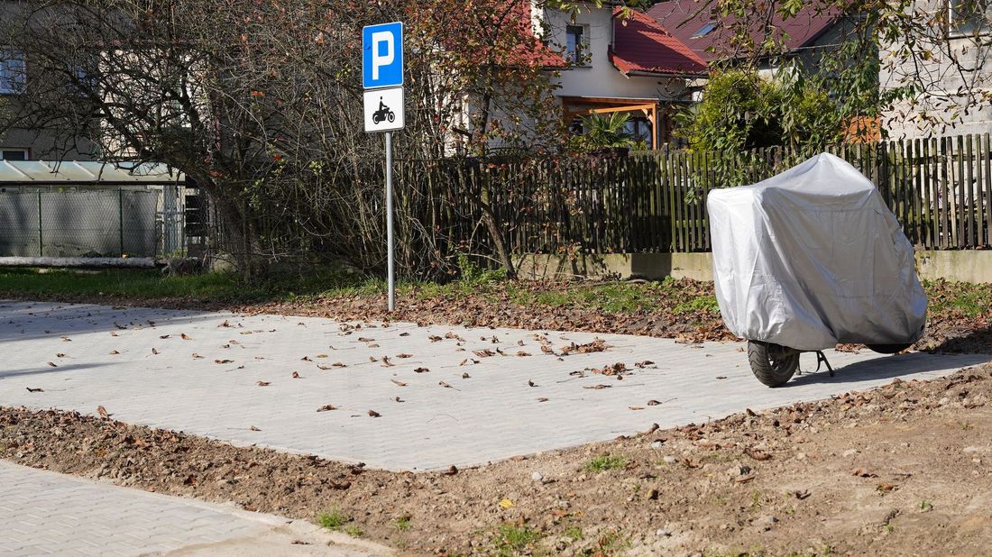 Zdjęcie przedstawia parking dla motocykli i motorowerów.