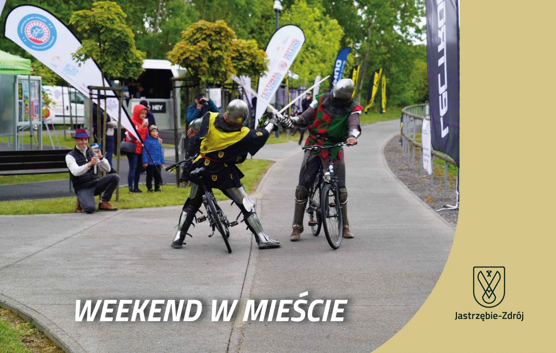 Dwóch rycerzy w zbrojach na rowerach na żelaznym szlaku rowerowym napis weekend w mieście