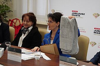 Prezydent Anna Hetman prezentuje ręcznik wchodzący w skład wyprawki jubileuszowej dla noworodka