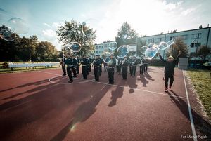 Orkiestra policji na boisku szkolnym.