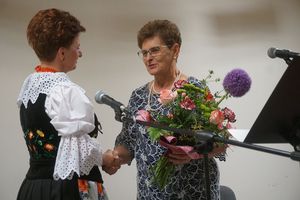 Prezes koła gospodyń wiejskich przyjmuje gratulacje od gości