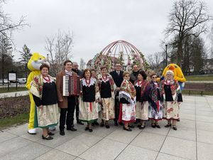 Panie z koła gospodyń wiejskich prezydent Michał Urgoł drugi zastępca Andrzej Matusiak przewodniczący rady miasta Piotr Szereda pozują do zdjęcia na tle jajka wielkanocnego