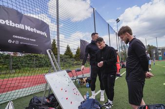 Ludzie patrzą na tablicę z drabinką turnieju 