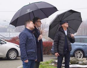 Goście z parasolami spoglądający na kościół 