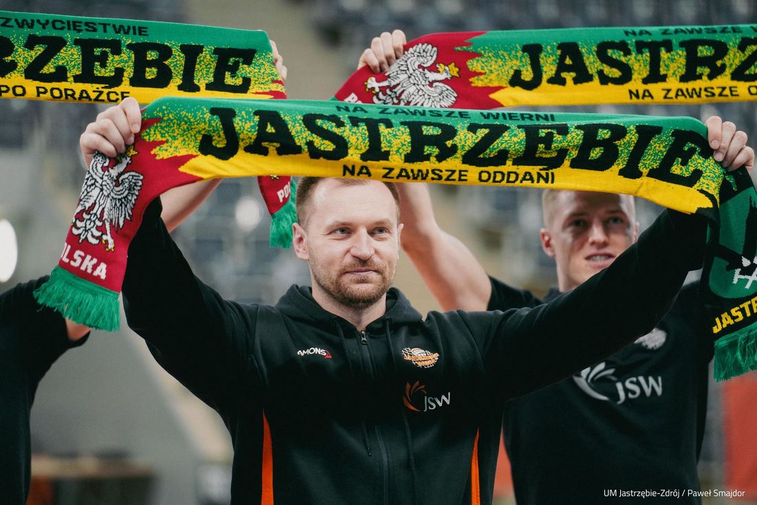 Adrian Staszewski trzyma szalik w barwach klubu