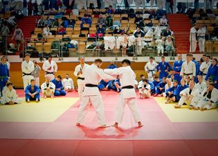 Początek walki judo. Zawodnicy łapia się na strój