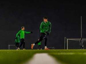 Piłkarze podczas treningu w środku pola w zielonych strojach