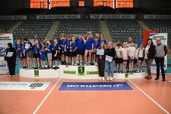 zawodnicy stoją na podium