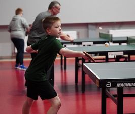 Chłopiec odbijający piłkę przy stole do ping-ponga