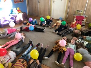 Dzieci leżące na podłodze i trzymające balony