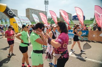 Dyrekotr Zofia Florek wręcza medal biegaczce w zielonym stroju do biegania