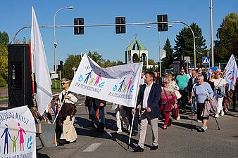 ludzie maszerują z transparentami w tłumie prezydent miasta