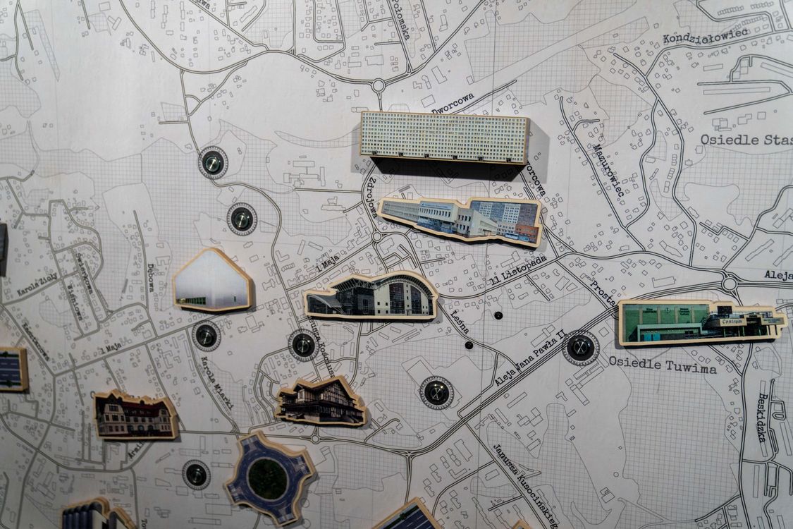 Fragment makiety z planem miasta, na którym umieszczono trójwymiarowe, drewniane miniatury charakterystycznych budynków użyteczności publicznej i osiedli