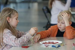 Dzieci wykonujące serce z koralików podczas warsztatów z metaloplstyki