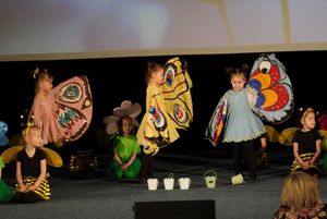 dzieci przebrane za kwiaty tańczą na scenie