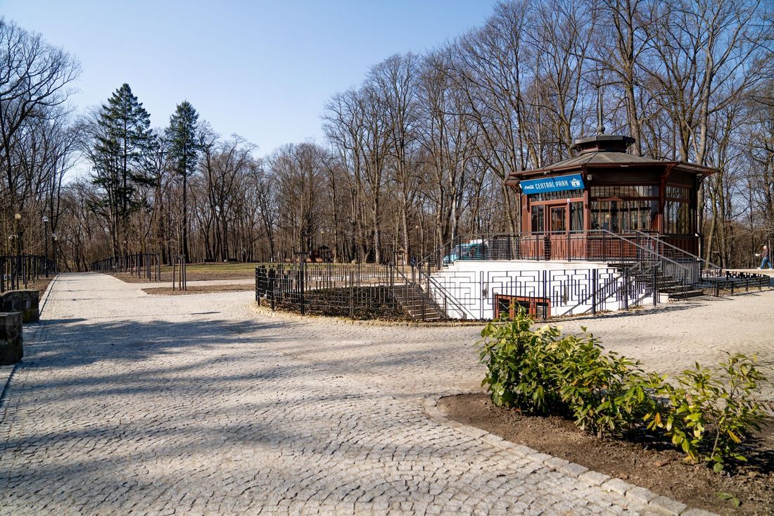 widok na drewnianą kawiarenkę a przed nią wybrukowany plac