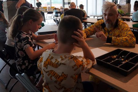 Pan Łukasz pomagający dzieciakom w układaniu