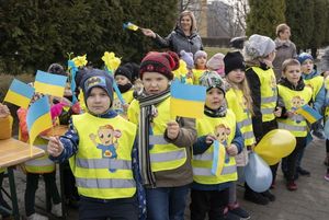 Dzieci w wieku przedszkolnym z chorągiewkami polskimi i ukraińskimi na placu WOŚP.