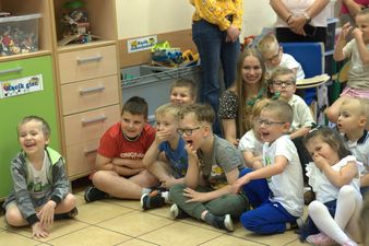 uśmiechnięte dzieci siedza na podłodze