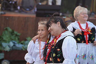 Kobieta w stroju ludowym przytula dziewczynkę
