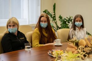 Spotkanie - uczestnicy siedzą przy stole i rozmawiają.