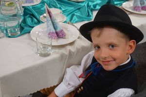 Chłopiec w stroju ludowym przy stole