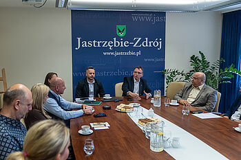 Członkowie rady biznesu i prezydent miasta Michał Urgoł siedzą przy stole i rozmawiaja
