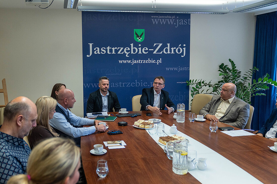 Członkowie rady biznesu i prezydent miasta Michał Urgoł siedzą przy stole i rozmawiaja
