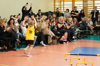 Najmłodsza siatkarka w koszulne z numerem 19 przebiega wzdłurz siedzacych gości w trakcie prezentacji
