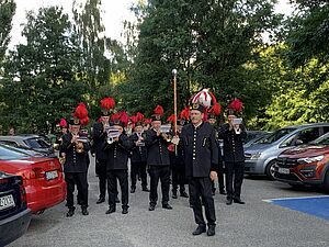Górnicza orkiestra dęta maszeruje i gra na parkingu osiedlowym