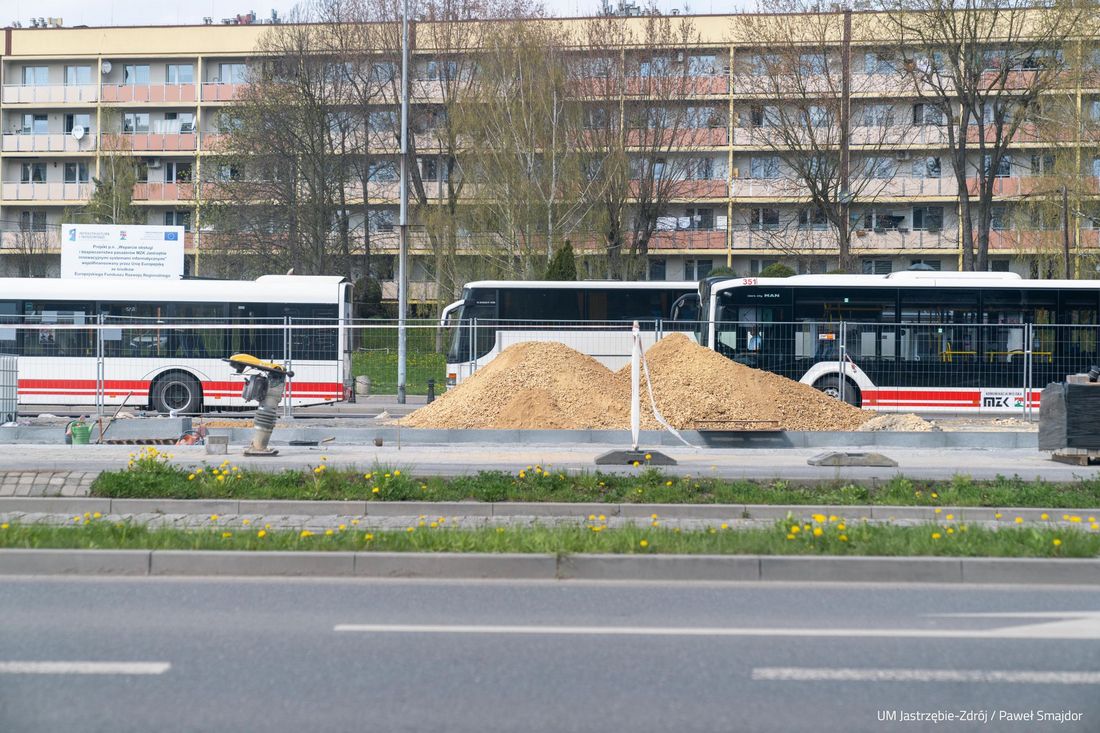 plac budowy dwa autobusy stoją przed nimi góra piasku