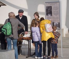 Dzieci i kobieta zgromadzenie przed tablicą z napisem Muszla koncertowa