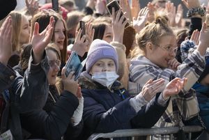 Dzieci i młodzież pod sceną słuchają muzyki.